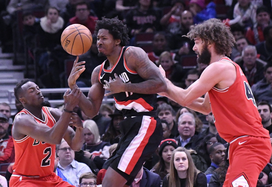 Portland Trail Blazers forward Ed Davis, center, Chicago Bulls guard Jerian Grant, left, and center Robin Lopez, right, go for a loose ball during the first half of an NBA basketball game, Monday, Jan. 1, 2018, in Chicago.