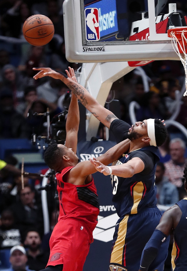 New Orleans Pelicans forward Anthony Davis, right, blocks a shot by Portland Trail Blazers guard CJ McCollum during the first half of an NBA basketball game in New Orleans, Friday, Jan. 12, 2018.