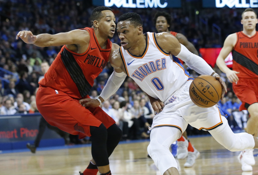Oklahoma City Thunder guard Russell Westbrook (0) drives around Portland Trail Blazers guard C.J. McCollum during the first quarter of an NBA basketball game in Oklahoma City, Tuesday, Jan. 9, 2018.