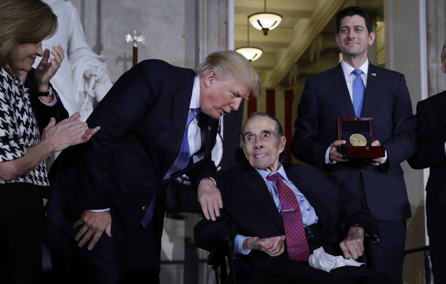 President Donald Trump speaks Wednesday to former Sen. Bob Dole before House Speaker Paul Ryan of Wis., right, presents him with the Congressional Gold Medal on Capitol Hill, in Washington.