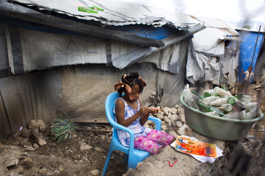 Seven-year-old Ducler Sarah Roudencia sharpens her pencil while she studies her lesson in the Caradeux refugee camp set up nearly eight years ago for people displaced by the 2010 earthquake, in Port-au-Prince, Haiti, on Thursday. Haitians reacted with outrage Friday to reports that President Donald Trump used a vulgar remark to describe the country on the eve of the anniversary of the 2010 earthquake, one of the deadliest disasters in modern history.