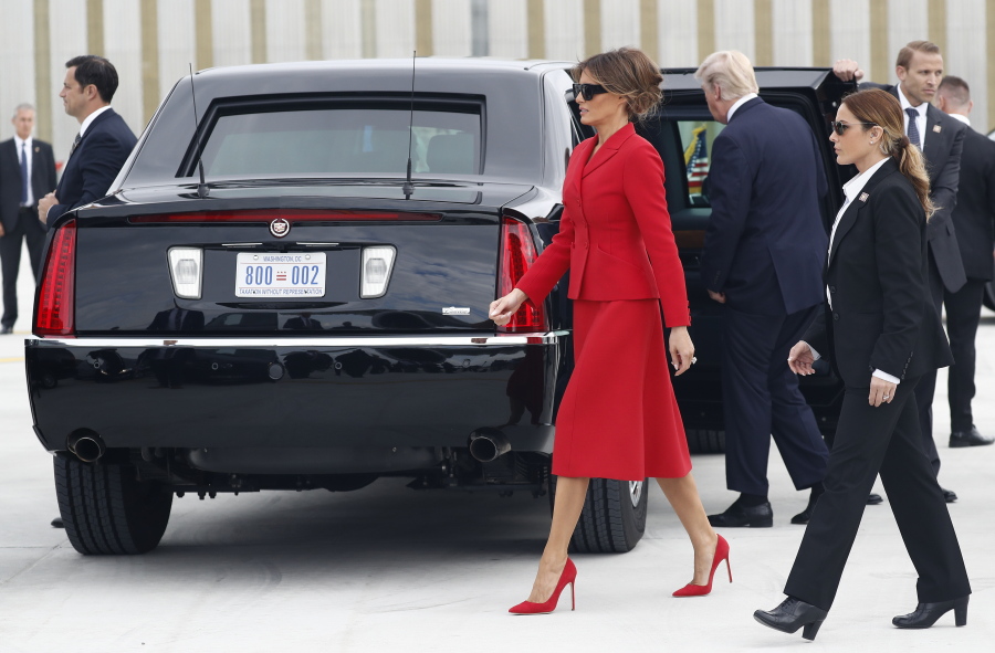 Melania Trump, center, walks the tarmac after arriving with President Donald Trump on Air Force One at Orly Airport, south of Paris, July 13. She is wearing a red Dior skirt suit.