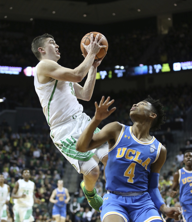Oregon’s Payton Pritchard, left, shoot over UCLA’s Jaylen Hands during the first half of an NCAA college basketball game Saturday, Jan. 20, 2018, in Eugene, Ore.