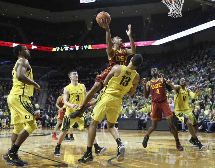 Southern California’s Jordan McLaughlin drives to the basket against Oregon players, including MiKyle McIntosh, left, Payton Pritchard and Paul White (13), with USC’s Chimezie Metu and Oregon’s Troy Brown Jr. watching at right during the second half of an NCAA college basketball game Thursday, Jan. 18, 2018, in Eugene, Ore. Referees first called a foul on White, but reversed the call to a player control foul on McLaughlin.