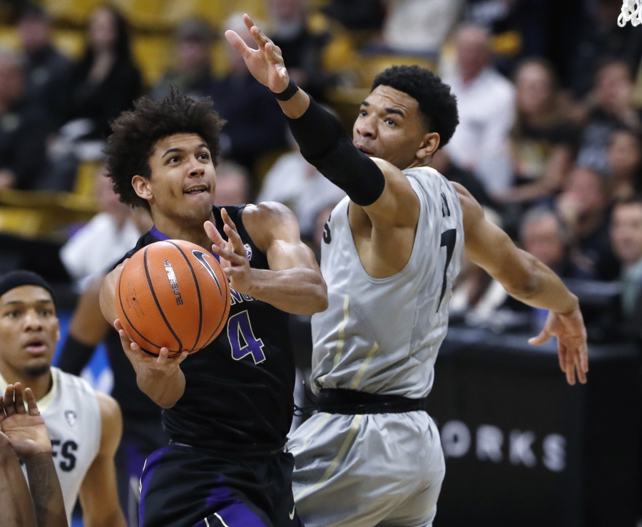 Washington guard Matisse Thybulle, left, drive to the basket past Colorado guard Tyler Bey during the first half of an NCAA college basketball game Saturday, Jan. 20, 2018.