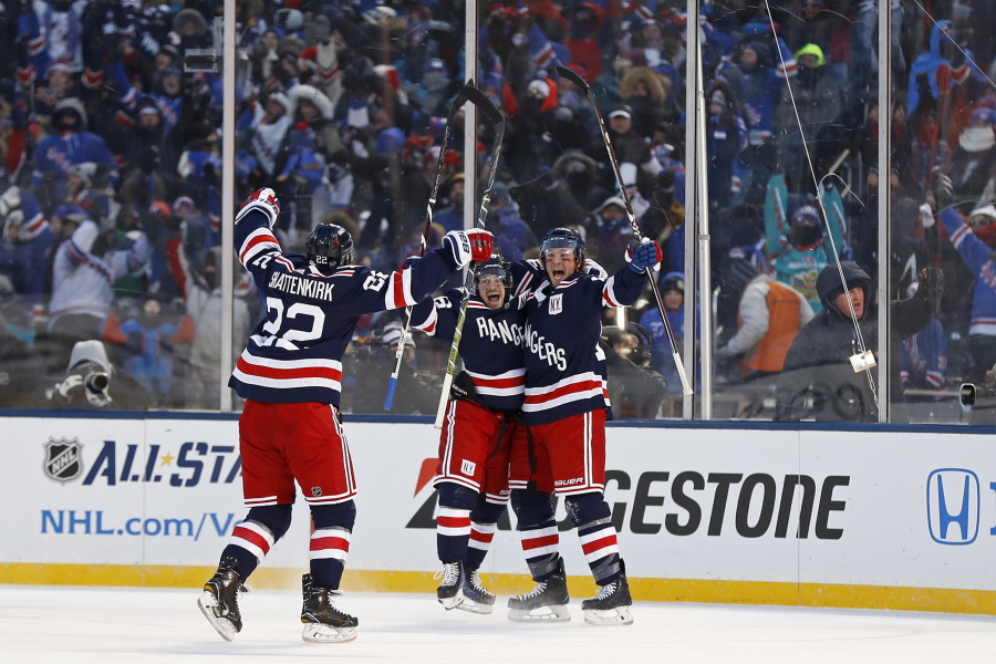 New York Rangers left wing J.T. Miller (10) celebrates scoring the game winning goal with Rangers right wing Mats Zuccarello (36) and Rangers defenseman Kevin Shattenkirk (22) against the Buffalo Sabres in overtime of the NHL Winter Classic hockey game at CitiField in New York on Monday, Jan. 1, 2018. The Rangers won 3-2.