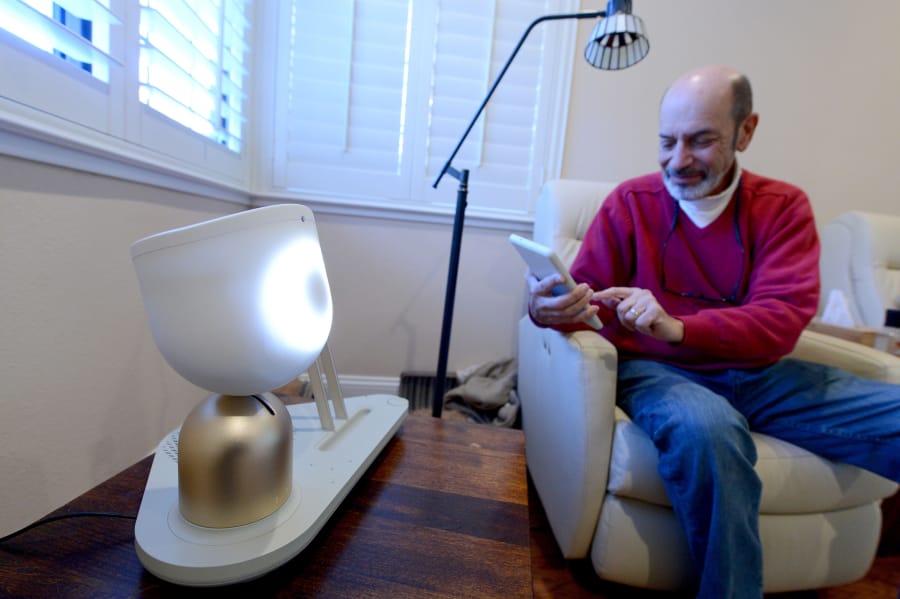 Barry Sardis interacts with ElliQ in his San Jose, Calif., home on Jan. 26. ElliQ, which is currently in beta testing, is a smart speaker that is designed to cater toward the elderly and their needs.