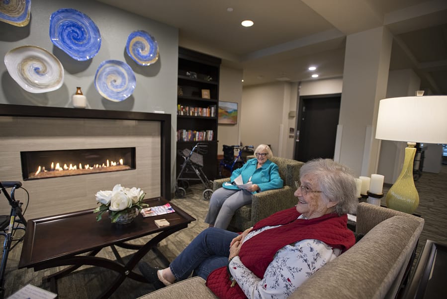 Florence Böelow, right, and Joyce Carr relax by the fire with friends at The Lofts at Glenwood Place. Böelow, 87, recently moved from an apartment in Portland to the independent living center to be closer to her children. “I needed some companionship,” she added.