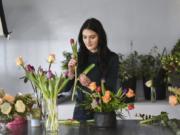 Kara Pyle, lead floral designer at Stem Floral Design in Vancouver, selects and prepares a flower for a customer’s arrangement.