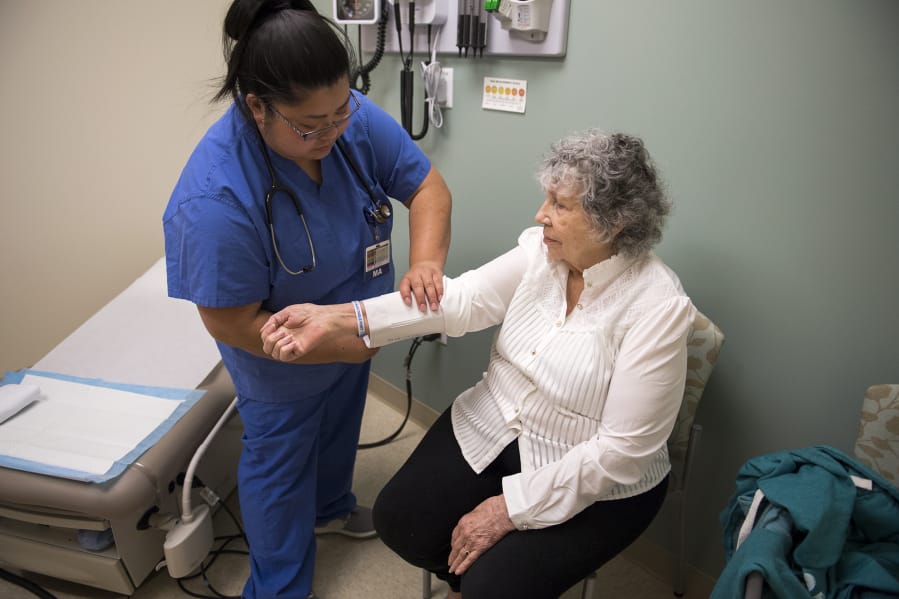 Medical assistant Leena Amphornphong takes Phyllis Peterson’s vitals during an appointment at Legacy Salmon Creek Medical Center. The Vancouver hospital is giving ovarian cancer patients, like Peterson, more opportunities to enroll in clinical trials.