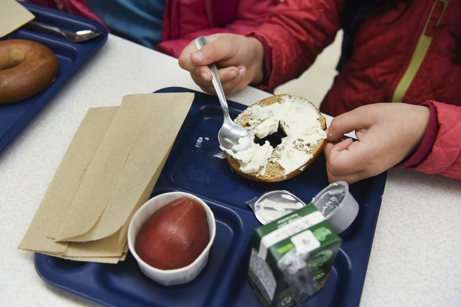 A student at Martin Luther King Elementary School in Vancouver spreads cream cheese on a whole-wheat bagel during breakfast Thursday morning. The elementary school is likely to be among schools affected by a bill proposed by Rep. Monica Stonier, D-Vancouver, to continue breakfast into the school day.