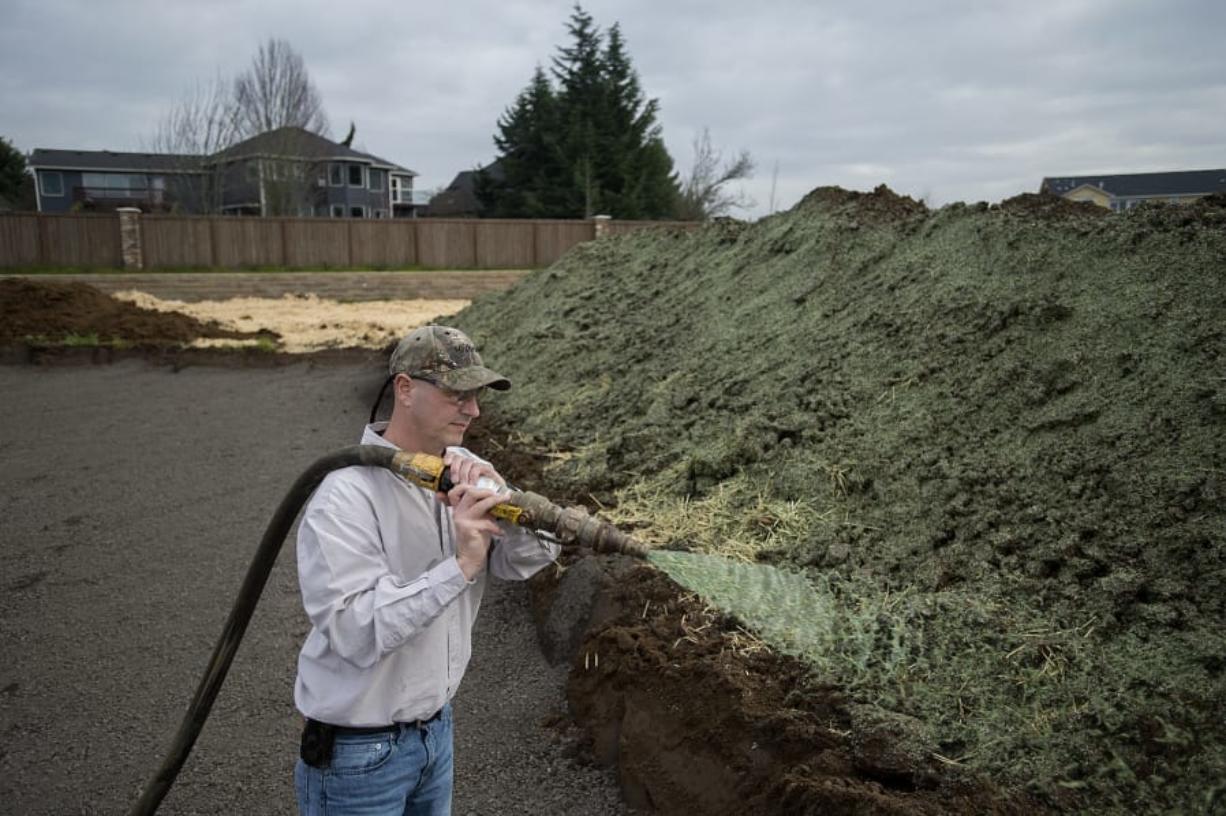John Dewitz, owner of Above & Beyond Hydroseed, sprays a stockpile of dirt to protect it from erosion at a Lennar Homes site in Felida’s Herzog Farm.