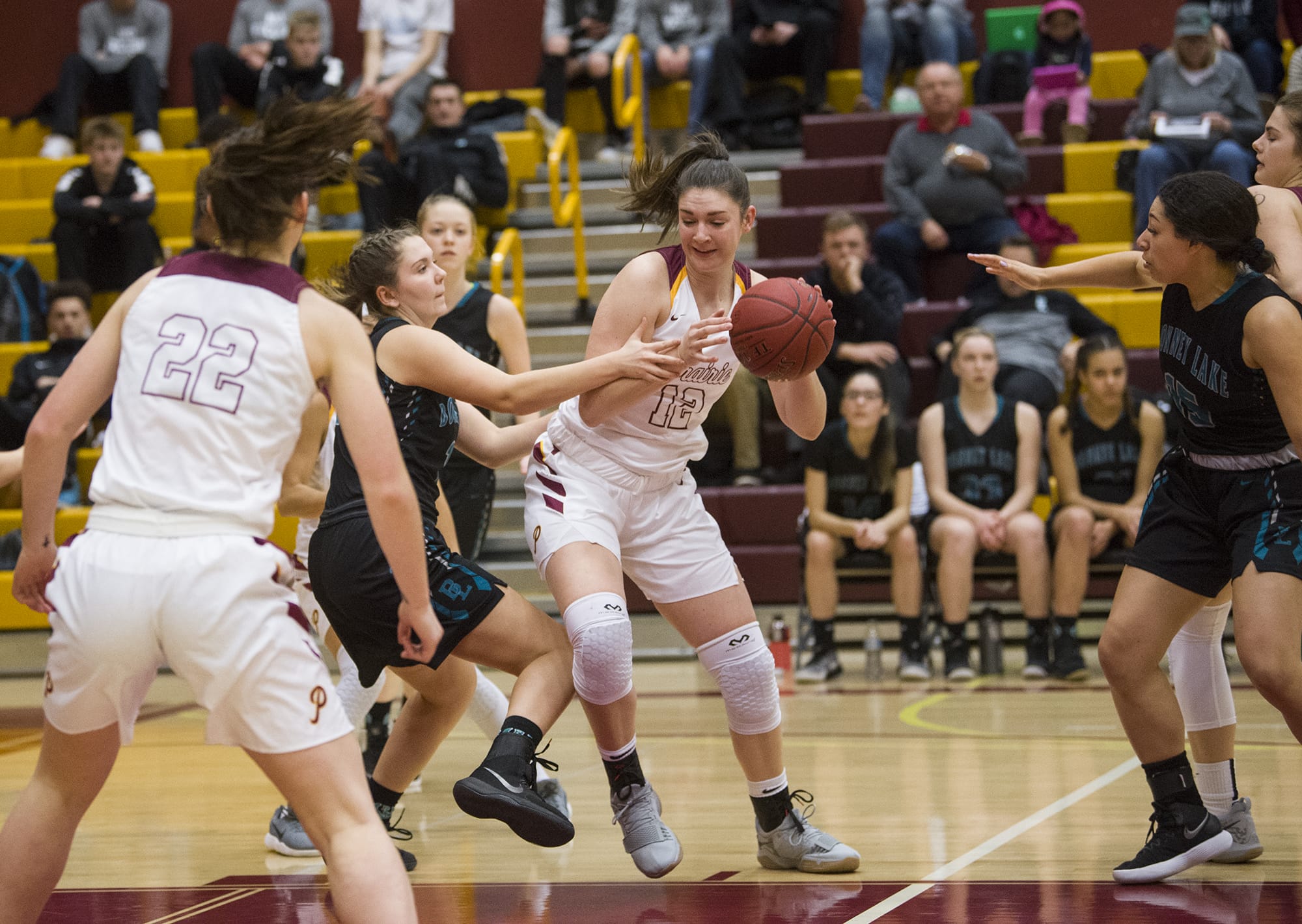 Prairie’s Brooke Walling (12) guards against Bonney Lake’s Olivia Grob (10) during the first round of the 3A bi-district girls basketball tournament at Prairie High School, Wednesday February 7, 2018.