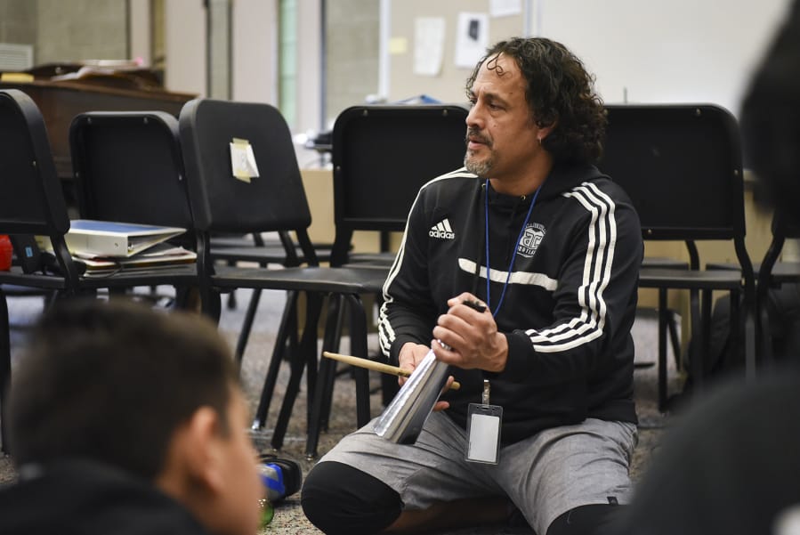 Edward Esparza, the leader of “One of a Kind Drumline,” an afterschool music program at Fort Vancouver High School, demonstrates the cowbell to elementary through high school students before drumeline rehearsal in the choir room at Fort Vancouver High School.