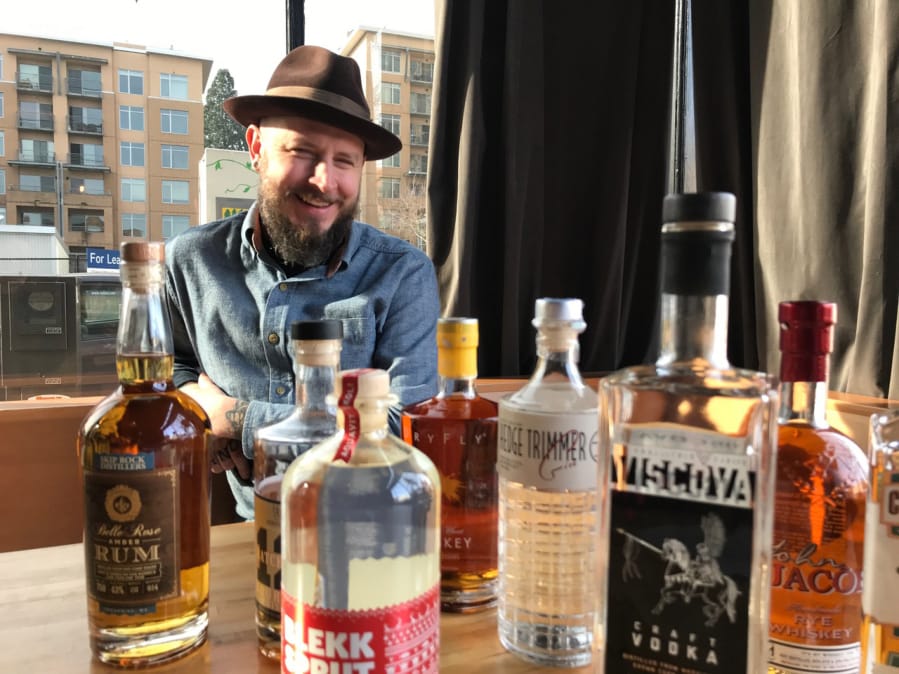 Chris “Salty” Reed with a collection of Washington spirits at The Grocery Cocktail & Social in downtown Vancouver.