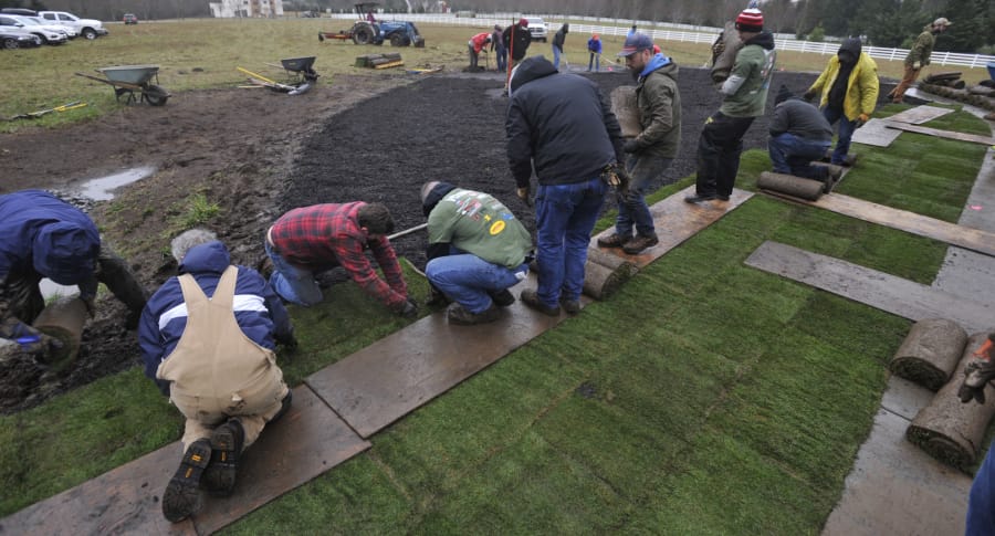 About 100 volunteers spent a soggy Saturday morning laying sod for Army Spc. Alex Hussey, who will receive the keys to a specially adapted custom home in Washougal in a few months. The home is being built and donated by the nonprofit Homes For Our Troops.
