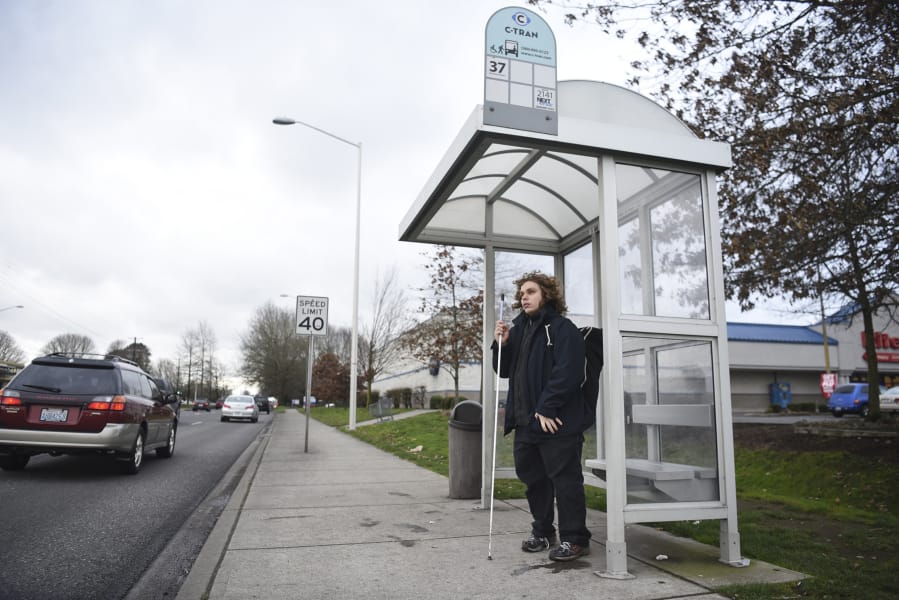 Nathaniel Baker, 19, of Vancouver, waits for the bus Friday on Mill Plain Boulevard near the intersection of Southeast 136th Avenue. C-Tran is working to develop a Mill Plain Boulevard Bus Rapid Transit corridor.