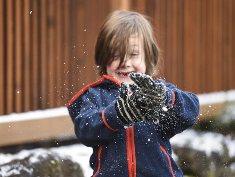 Quinten Flatt, 6, brushes snow off his gloves while taking a walk with his parents in the Hough neighborhood, Monday morning, February 19, 2018.