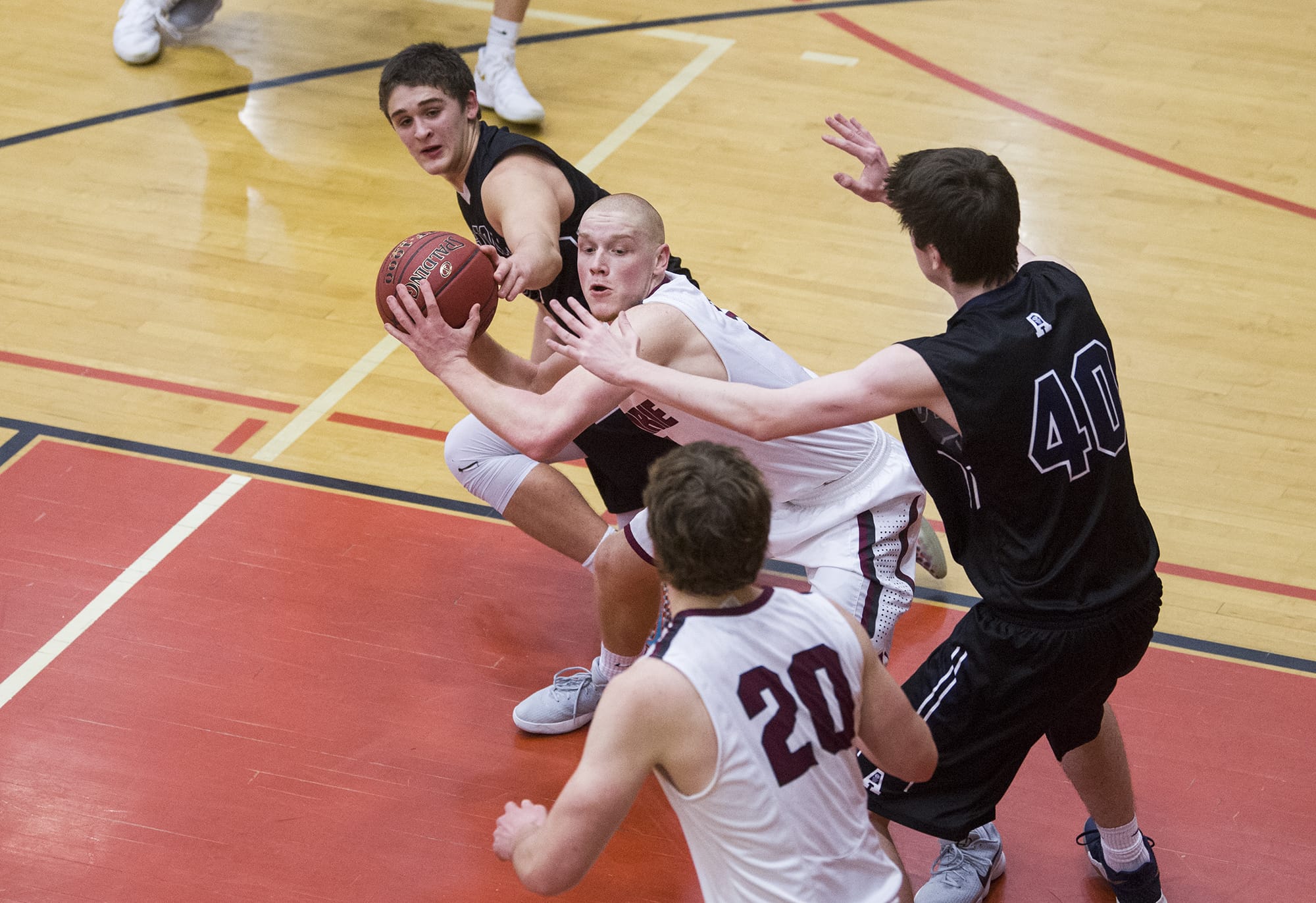 Prairie’s Kameron Osborn (3) prepares to make a pass to Prairie’s Logan Reed (20) while guarding from Arlington’s Max Smith (40) and Griffin Gardoski (3) during the 3A regional boys basketball game at Battle Ground High School, Saturday February 24, 2018.
