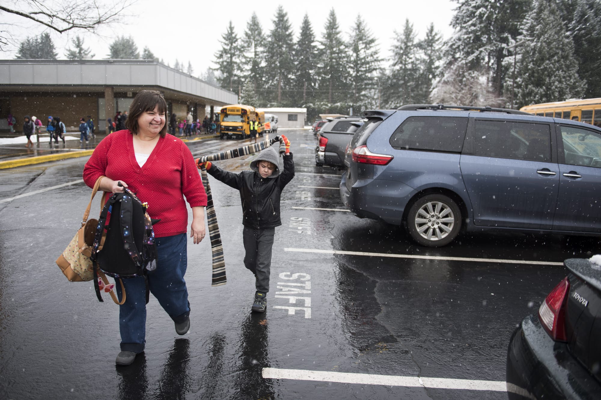 Jill Loveridge picks up her grandson Erik Lamb, 8, for early release at Pleasant Valley Primary School in Vancouver on Tuesday morning. Loveridge is a math teacher at Battle Ground High School and said her students couldn't contain their excitement. She started playing "Do you want to build a snowman?" for them as their classes started to let out earlier that morning.