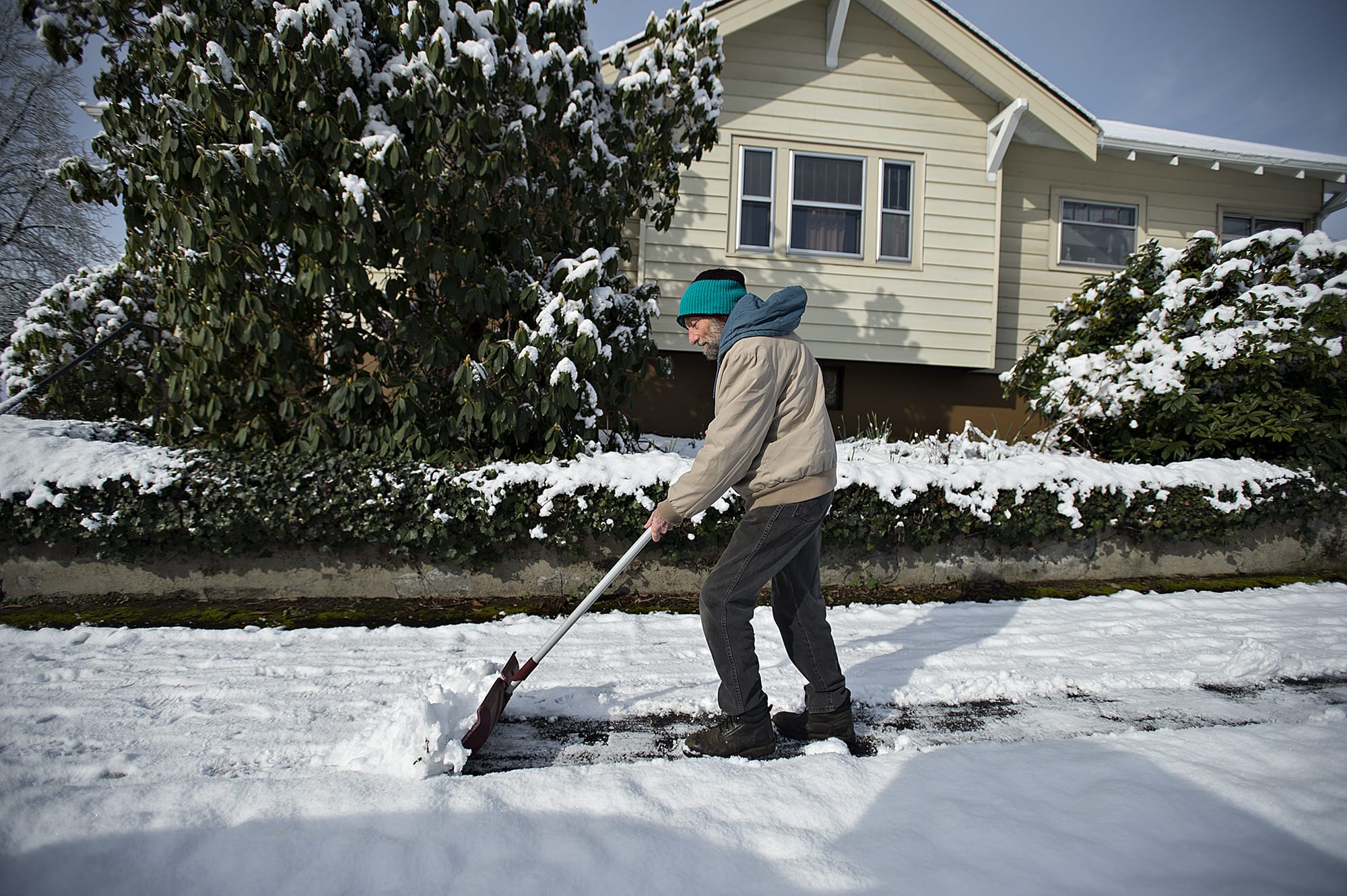 John Lemley of Vancouver lends a kind hand to a neighbor as he shovels a sidewalk in the Lincoln neighborhood Wednesday morning, Feb. 21, 2018.