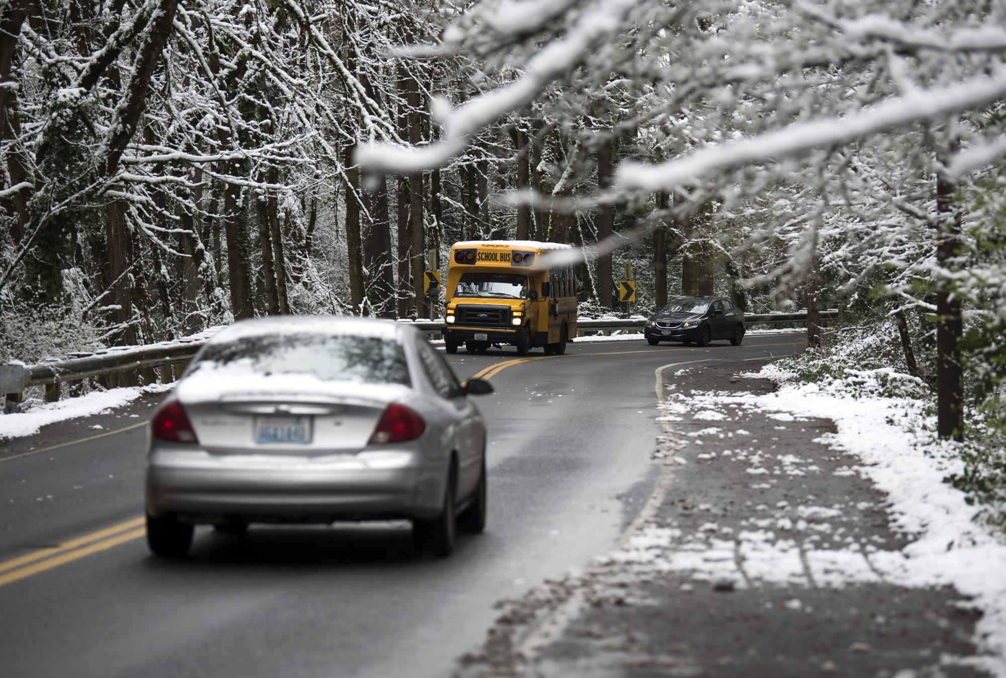 Many local schools operated with a late start on Thursday morning, but because temperatures lingered just above freezing the freeways and metro-area streets were mostly bare. Drivers are seen along Blandford Drive canyon from MacArthur Boulevard to Evergreen Boulevard late Thursday morning, Feb. 22, 2018, in Vancouver.
