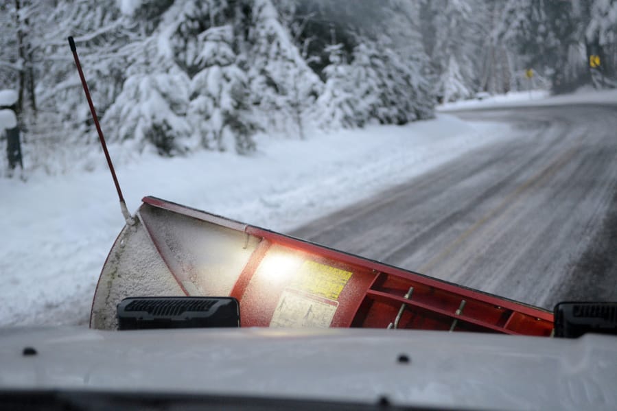 With the road cleared, Nick Eiesland, lets the snowplow blade hang from the front of truck. Working overnight Wednesday, snowplow crews cleared primary and secondary roads across Clark County.