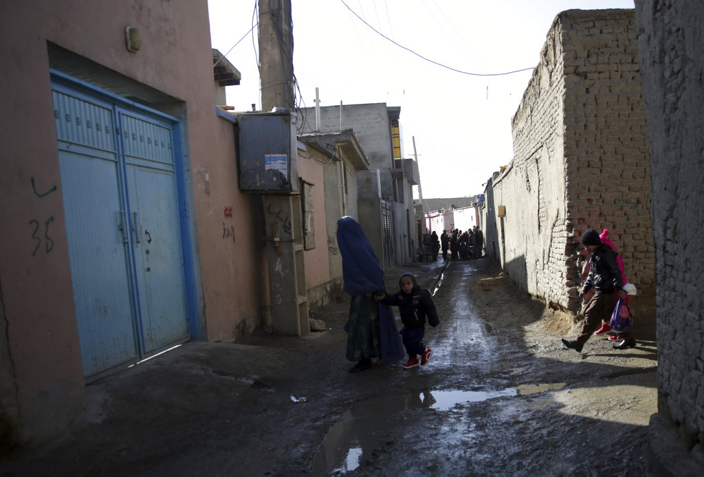 Residents walk on a street of the Qala-e-Walid neighborhood in Kabul, Afghanistan, Friday, Feb. 2, 2018. The Afghan authorities found an Islamic State hideout packed with explosives in a poor western neighborhood of the capital where residents of the area say they rarely see a police patrol, and marauding bands of thieves makes it unsafe to be on the streets after dark.