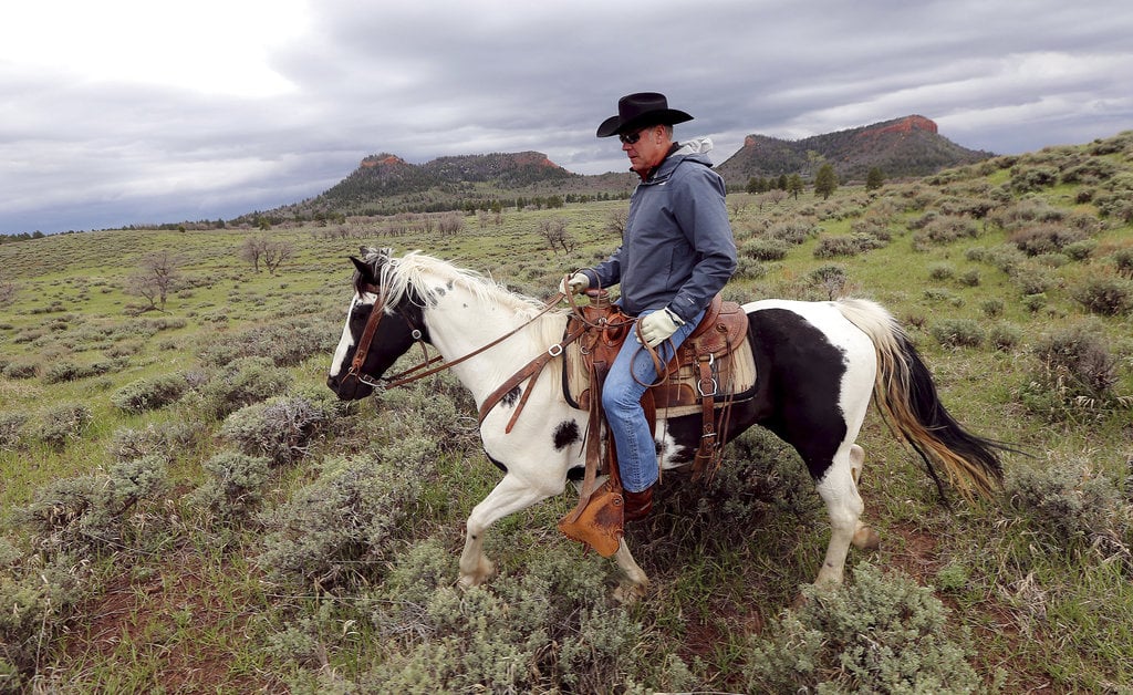 FILE - In this May 9, 2017, file photo, Interior Secretary Ryan Zinke rides a horse in the new Bears Ears National Monument near Blanding, Utah. Much of Bears Ears is on land administered by the Bureau of Land Management, which is part of Zinke's department. Western lawmakers are arguing that BLM headquarters should be moved from Washington, D.C., to the West because of its influence there.
