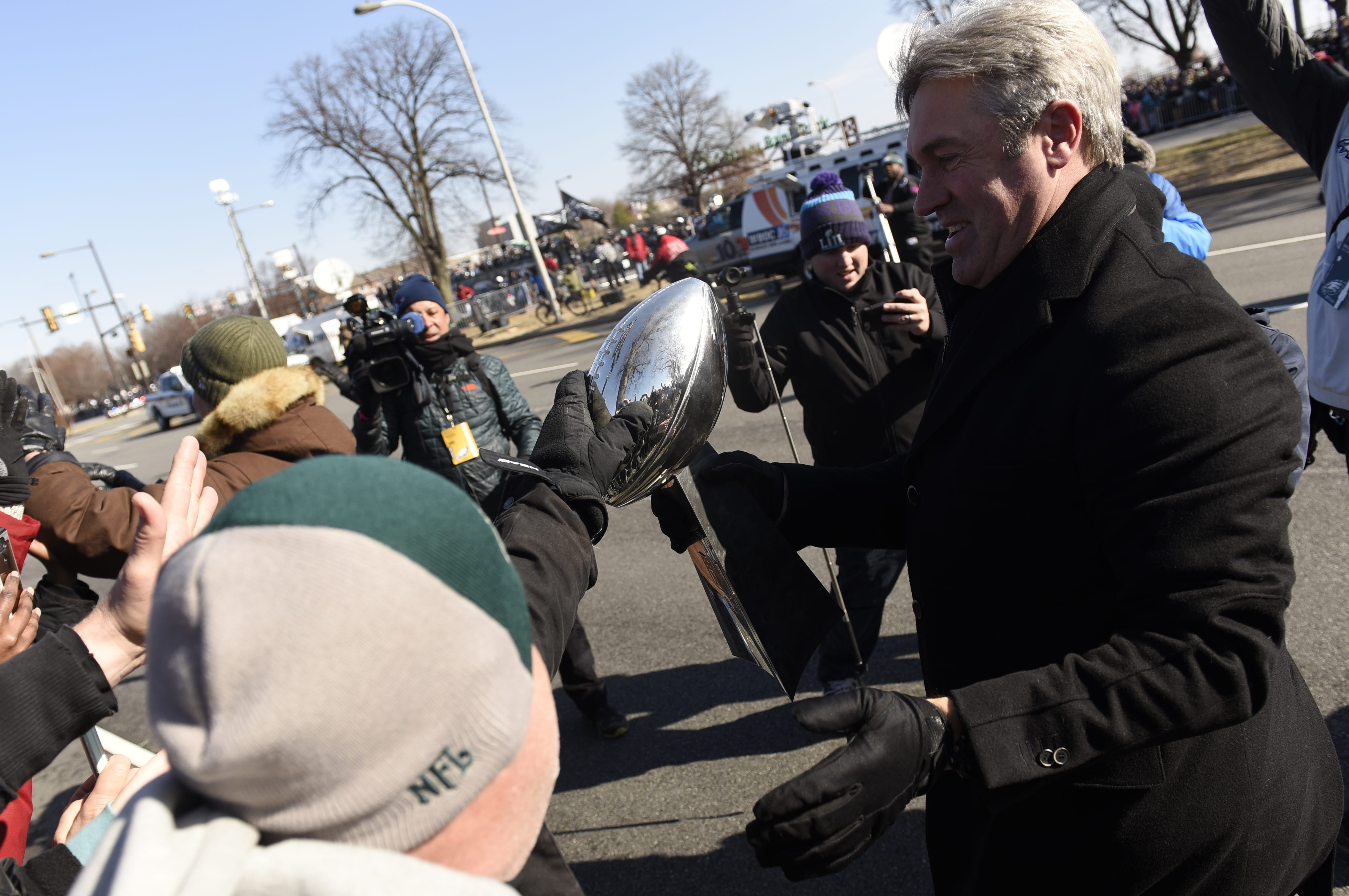 A fan reaches out to touch the Lombardi Trophy carried by Philadelphia Eagles NFL football team head coach Doug Pederson during the Super Bowl LII victory parade, Thursday, Feb 8, 2018, in Philadelphia.