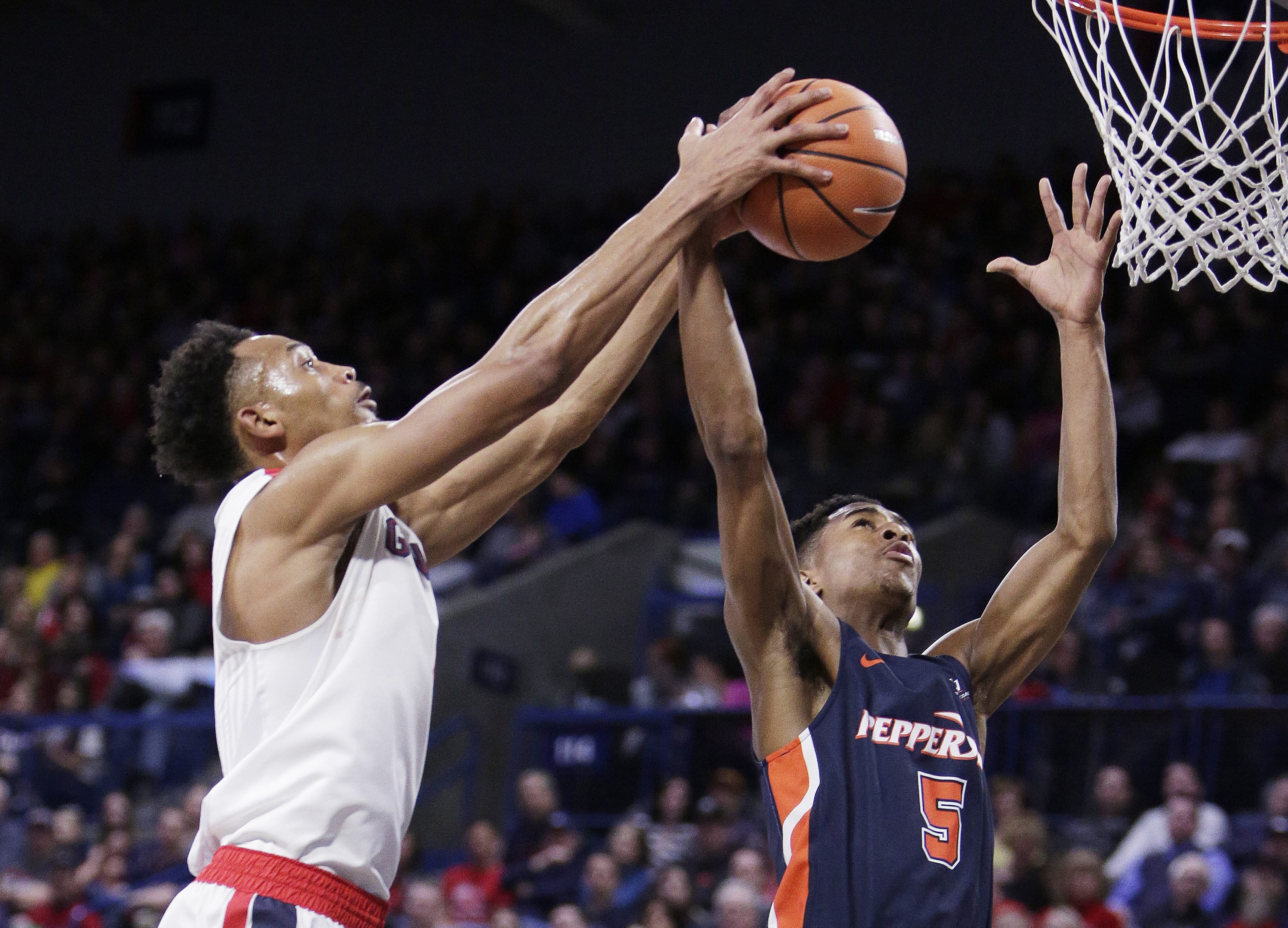 Pepperdine guard Jade' Smith (5) and Gonzaga forward Johnathan Williams go after a rebound during the first half of an NCAA college basketball game in Spokane, Wash., Saturday, Feb. 17, 2018.