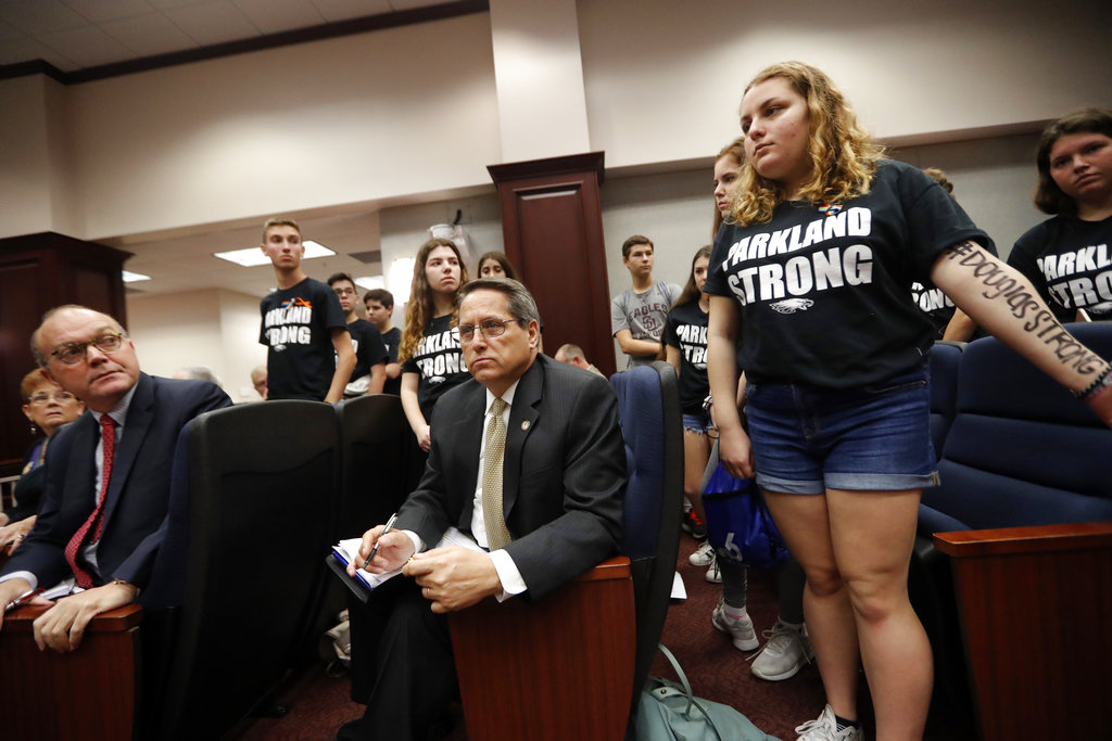 Lobbyists and attorneys listen as student survivors from last Wednesday's mass shooting at Marjory Stoneman Douglas High School interrupt a house legislative committee hearing in the hope to challenge lawmakers on gun control reform in Tallahassee, Fla., Wednesday, Feb. 21, 2018.