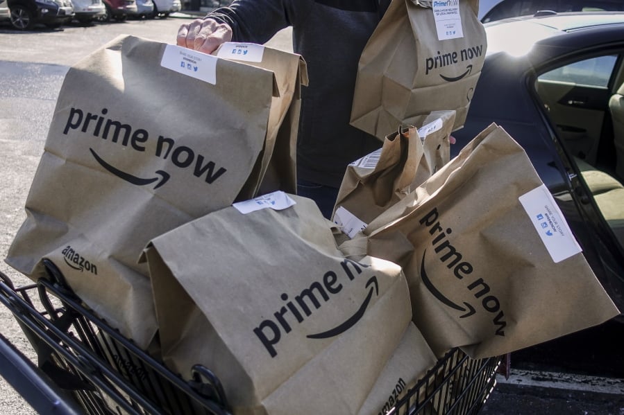 Amazon Prime Now bags full of groceries are loaded for delivery by a part-time worker outside a Whole Foods store, Thursday, Feb. 8, 2018, in Cincinnati. Amazon, which owns Whole Foods, plans to roll out two-hour delivery at the organic grocer this year to those who pay for Amazon’s $99-a-year Prime membership. Amazon.com Inc. said deliveries started Thursday in Austin, Texas; Cincinnati; Dallas; and Virginia Beach, Va.