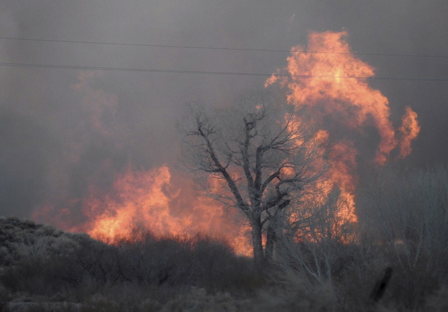 Smoke rises from wildfires Sunday near Bishop, Calif. A wind-driven wildfire in rural central California threatened hundreds of buildings Monday, including a historic railroad station, officials said.