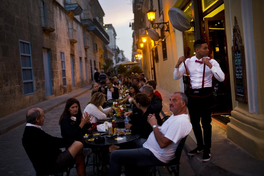 A waiter serves customers at a private restaurant’s outdoor seating in Havana, Cuba, on Wednesday. Eight years after Cuba’s President Raul Castro widened the niche for private enterprise in Cuba’s state-dominated economy, he has thrown the brakes on, raising fundamental questions about the nation’s economic path.