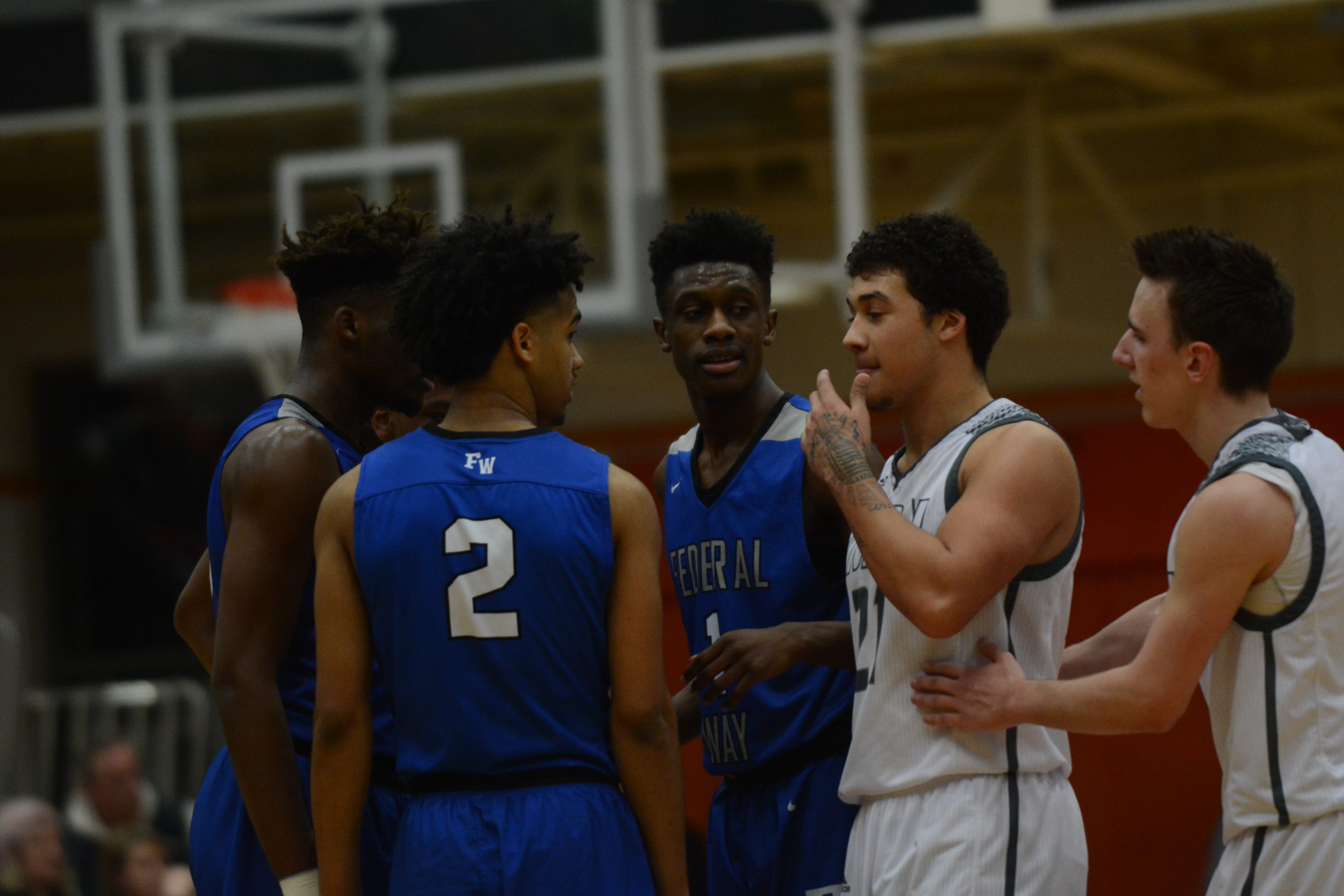 Ethan Smith ushers Union's Dustin Nettles away from a Federal Way huddle in the fourth quarter of the Titans' 75-65 overtime loss to Federal Way in the 4A state tournament on Saturday, Feb.