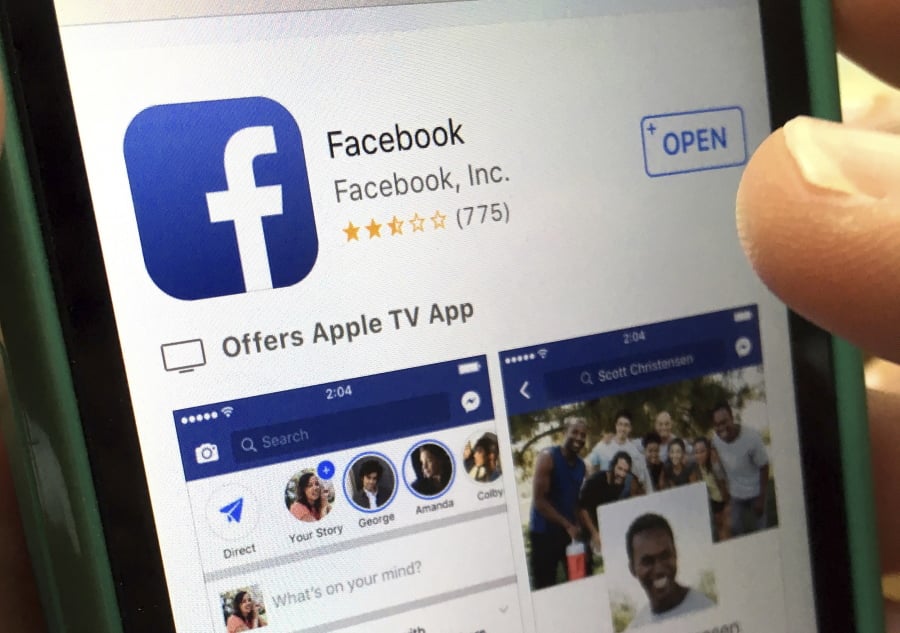 FILE - In this June 19, 2017, file photo, a user gets ready to launch Facebook on an iPhone, in North Andover, Mass. Seattle Ethics and Elections Commission said in a statement Monday, Feb. 5, 2018, that Facebook is violating city and state laws that require disclosure of who pays for political advertising.