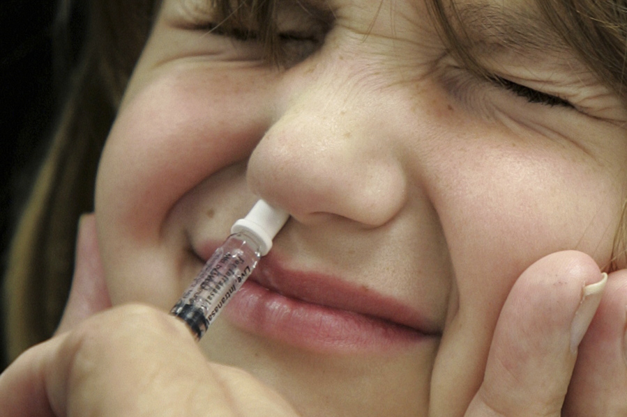FILE - In this Oct. 4, 2005 file photo, Amanda Klopfer reacts as she is given a FluMist influenza vaccination in St. Leonard, Md. On Wednesday, Feb. 21, 2018, a federal panel says it’s OK for doctors to start using the kid-friendly nasal spray flu vaccine again.