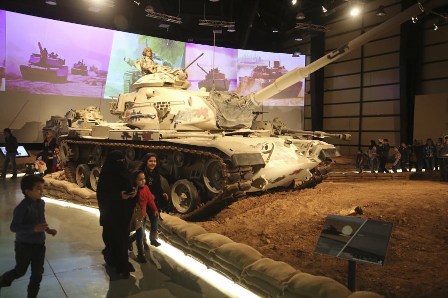 A family walks past a tank Feb. 1 at the Royal Tank Museum in Amman, Jordan. The museum displaying 110 battle-worn tanks from a century of wars in the Middle East and from more distant conflicts opened last week.