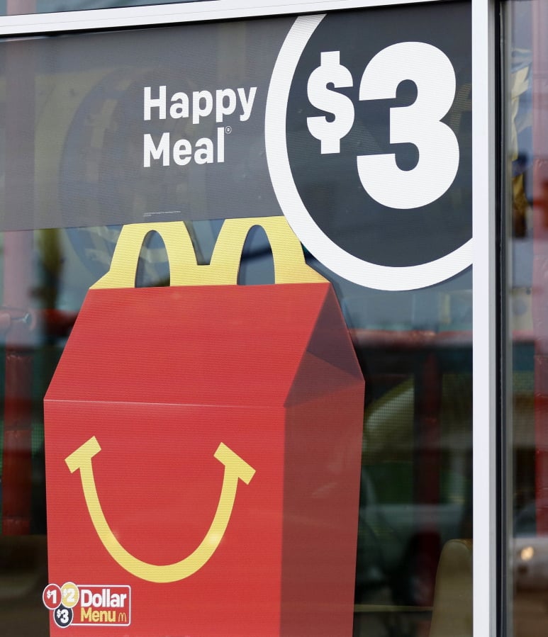 A $3 Happy Meal is advertised at a McDonald’s restaurant in Brandon, Miss., Wednesday. McDonald’s will soon banish cheeseburgers and chocolate milk from its Happy Meal menu in an effort to cut down on the calories, sodium, saturated fat and sugar that kids consume at its restaurants. (AP Photo/Rogelio V.