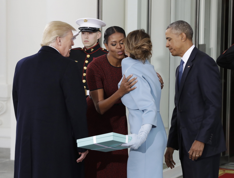 First lady Michelle Obama, flanked by President Barack Obama and then President-elect Donald Trump, greets Melania Trump at the White House in Washington.