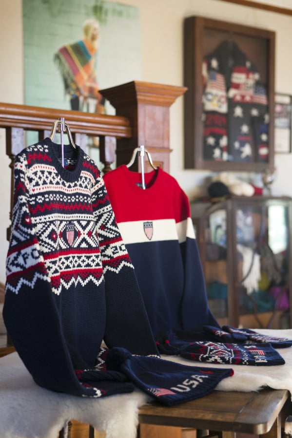 In this Monday, Feb. 12, 2018 photo, the opening and closing ceremony sweaters worn by Team USA Olympic athletes, coaches, and staff are displayed in the Hinton House, a showcase for some of the products made from wool from the Imperial Stock Ranch, at the ranch in Shaniko, Ore. On the wall behind them is a case containing the opening ceremony sweater for the 2014 Sochi Olympics, also made from Imperial Stock Ranch wool.