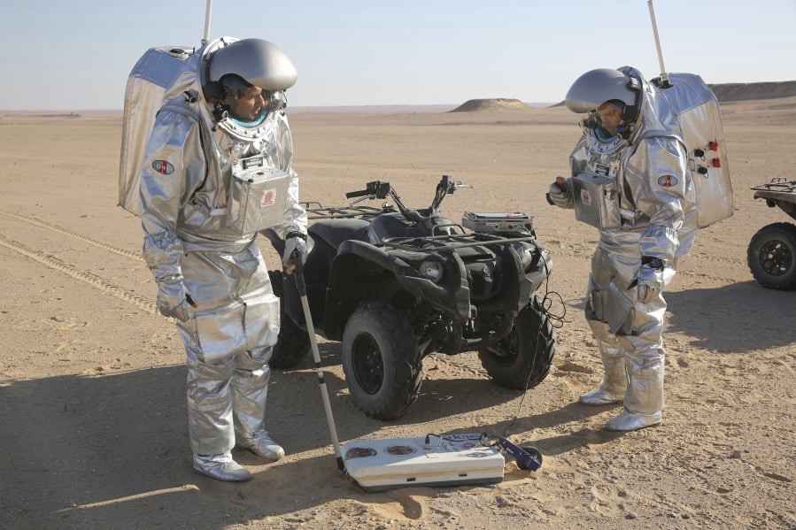 Two scientists test space suits and a geo-radar Thursday in the Dhofar Desert in Oman.