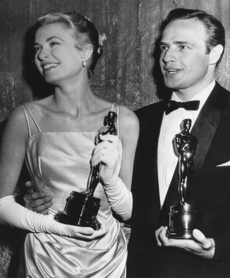 Grace Kelly, left, and Marlon Brando hold their best actress and actor Oscars on March 31, 1955, in Los Angeles. Kelly’s icy green satin gown was designed by Edith Head.