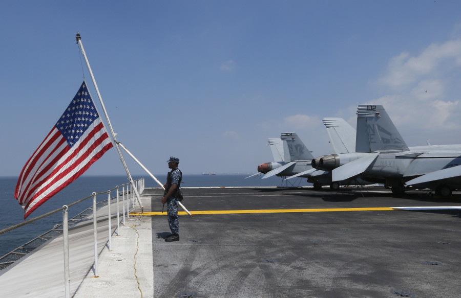 A U.S. Marine stands guard on the flight deck of the USS Carl Vinson aircraft carrier anchors off Manila, Philippines, for a five-day port call along with guided-missile destroyer USS Michael Murphy, Saturday, Feb. 17, 2018. Lt. Cmdr. Tim Hawkins told The Associated Press that American forces will continue to patrol the South China Sea wherever international law allows when asked if China’s newly built islands could restrain them in the disputed waters.