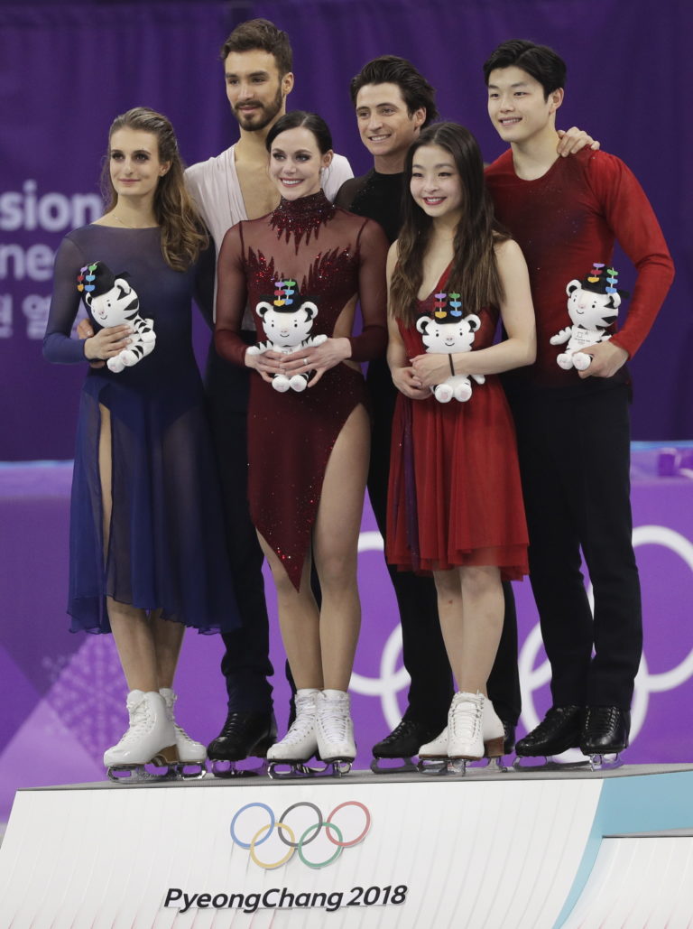 Tessa Virtue and Scott Moir of Canada, centre, celebrate on the podium with second placed Gabriella Papadakis and Guillaume Cizeron of France, left and third placed Maia Shibutani and Alex Shibutani of the United States at right, after winning the gold medal in the ice dance, free dance figure skating final in the Gangneung Ice Arena at the 2018 Winter Olympics in Gangneung, South Korea, Tuesday, Feb. 20, 2018. (AP Photo/David J.