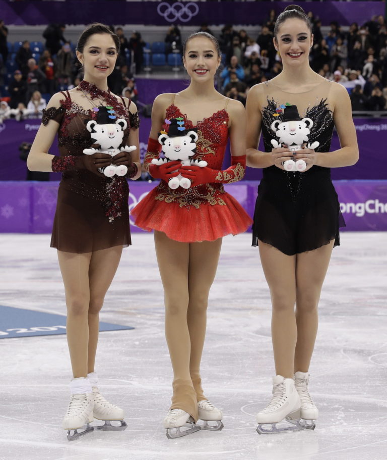 Gold medalist Alina Zagitova, centre, of the Olympic Athletes of Russia poses for a photo with compatriot and silver medalist Evgenia Medvedeva, left, and bronze medalist Kaetlyn Osmond of Canada at the women's free figure skating final in the Gangneung Ice Arena at the 2018 Winter Olympics in Gangneung, South Korea, Friday, Feb. 23, 2018. (AP Photo/David J.