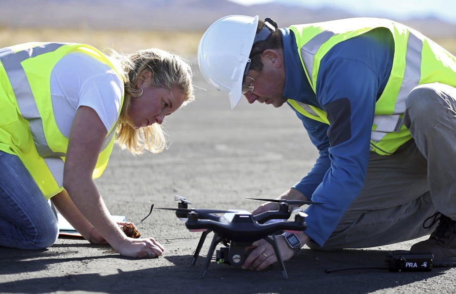 Jessica Balik, left, and Keven Gambold, right, CEO of Unmanned Experts, prepare a drone for a demonstration at the Searchlight airport in Searchlight, Nev., on Wednesday, Jan. 17, 2018.