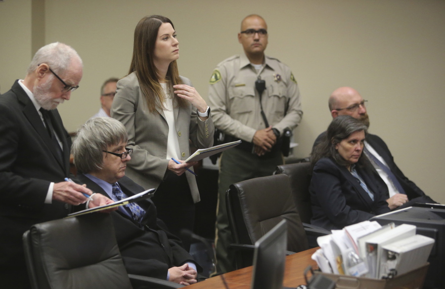Attorneys, standing, David Macher, left, and Allison Lowe appear with their clients, David Turpin, second from left, and Louise Turpin, second from right, Friday in court in Riverside, Calif. The Turpins are accused of starving and shackling some of their 13 children.