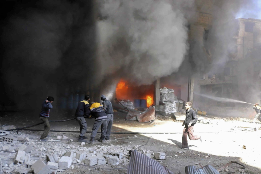 Members of the Syrian Civil Defense extinguishing a store during airstrikes and shelling by Syrian government forces, in Ghouta, a suburb of Damascus, Syria. Intense Syrian government shelling and airstrikes of rebel-held Damascus suburbs killed at least 100 people since Monday in what was the deadliest day in the area in three years, a monitoring group and paramedics said Tuesday.